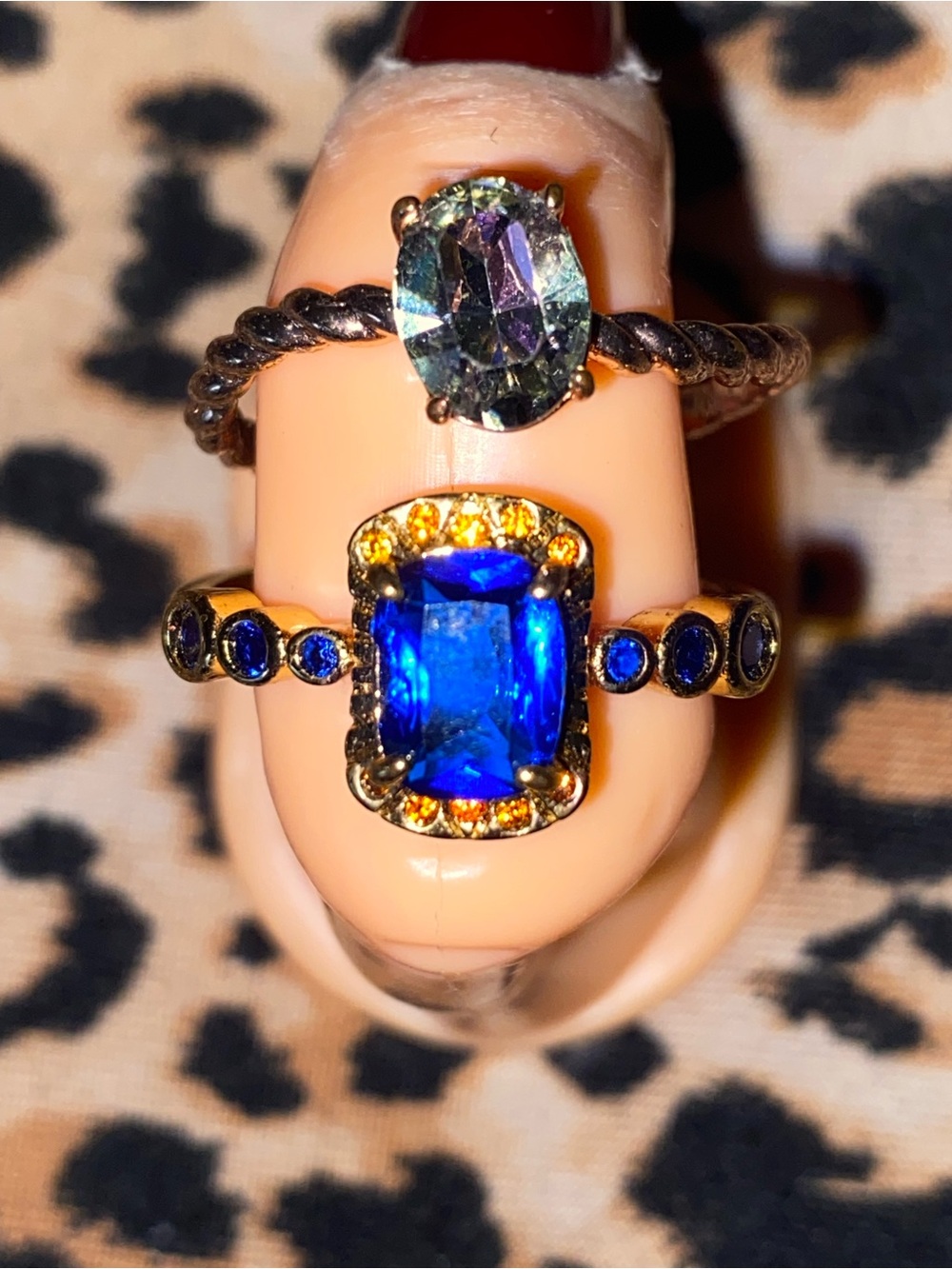 A Blue gem gold ring with small blue gems and a purple, blueish gold ring